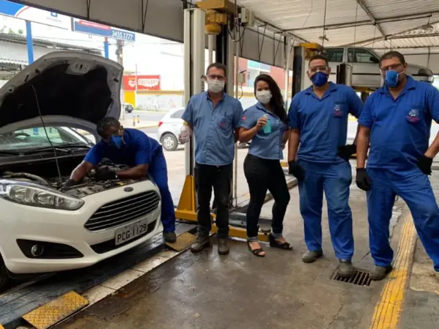 Equipe da Auto Center 2000 ao lado de um carro em manutenção