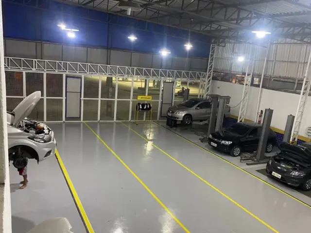 Oficina ampla e organizada, com carros nos elevadores